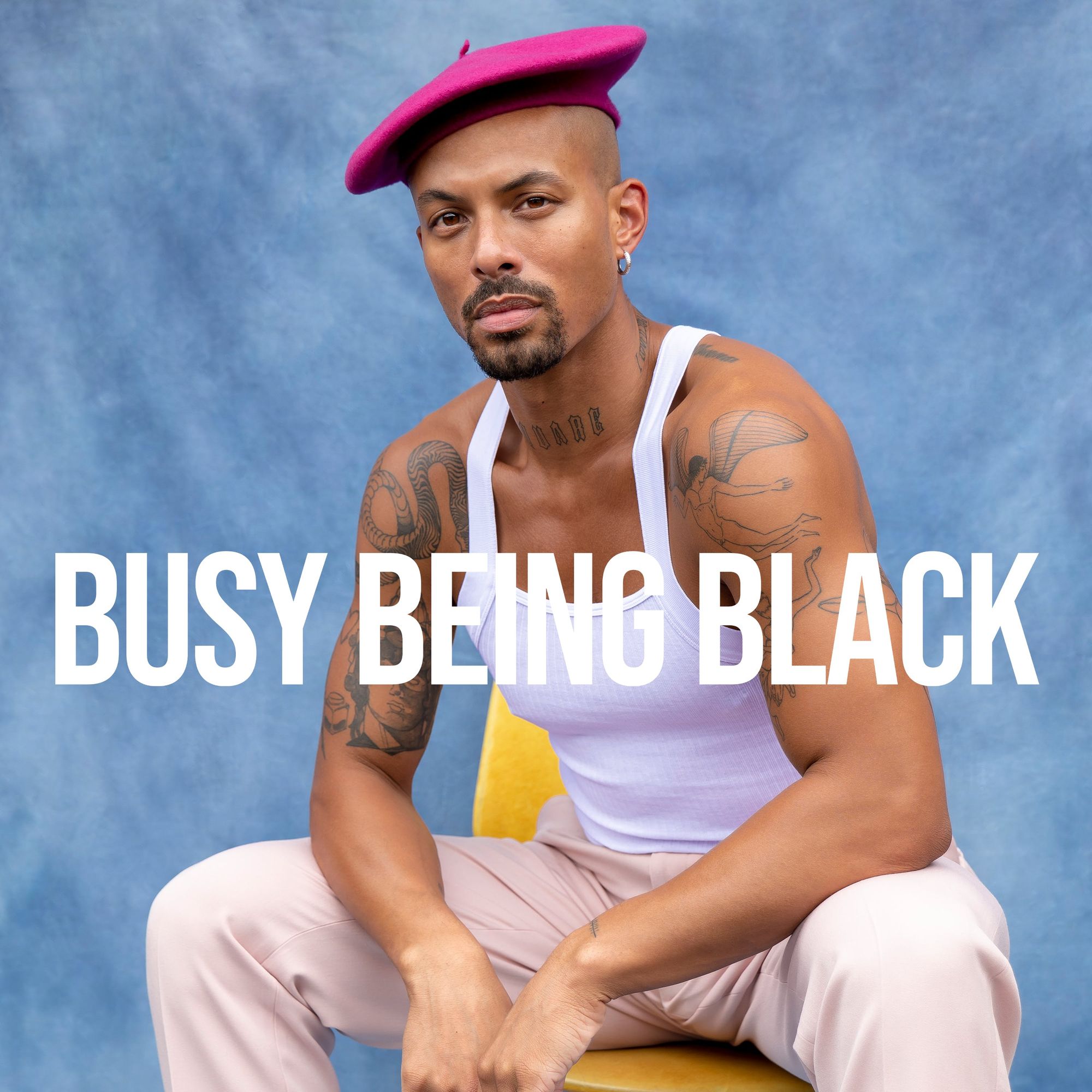 Man in pink beret and white tank top on blue background