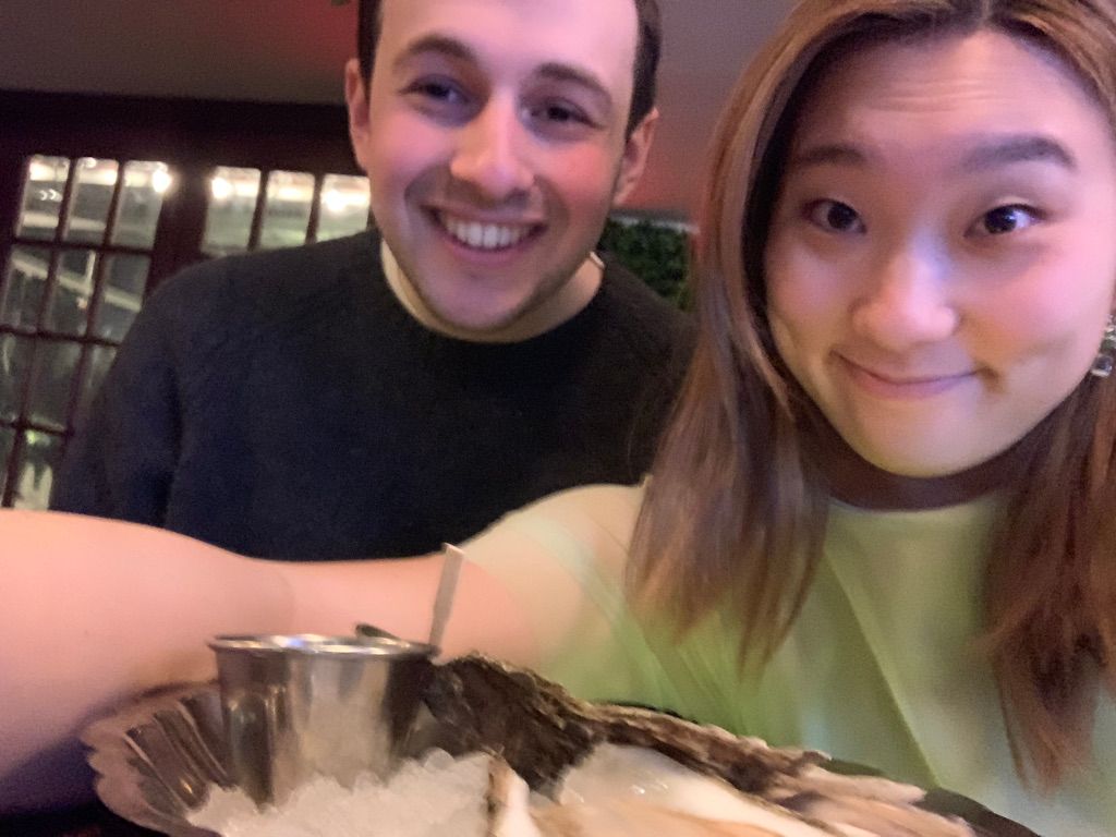 Emma and her boyfriend, smiling over oysters