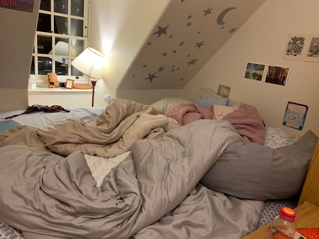 Very large bed with lots of blankets and star stickers on the wall