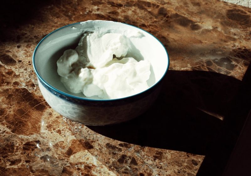 Yogurt in a bowl on a marble countertop. 