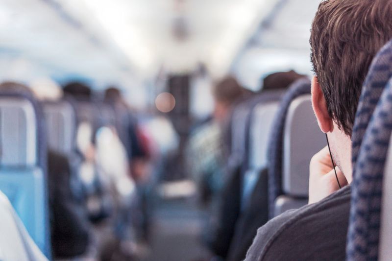 Airplane picture shot from the back. Man's back of head. 