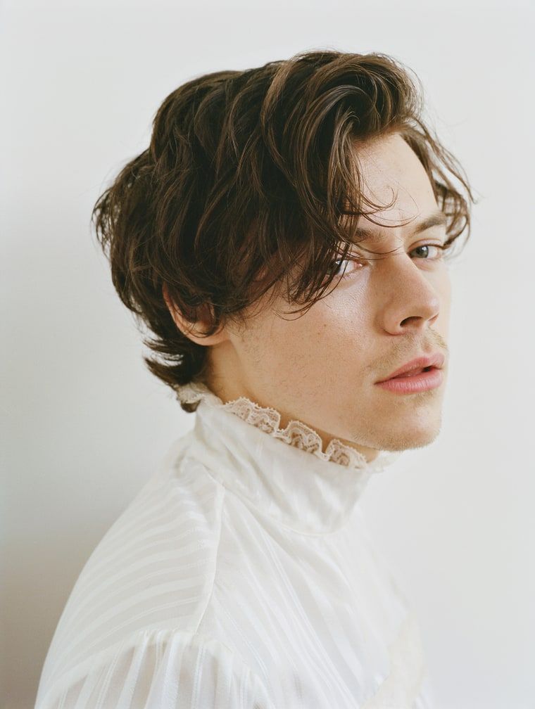 Harry Styles side profile with collared white organza shirt. 