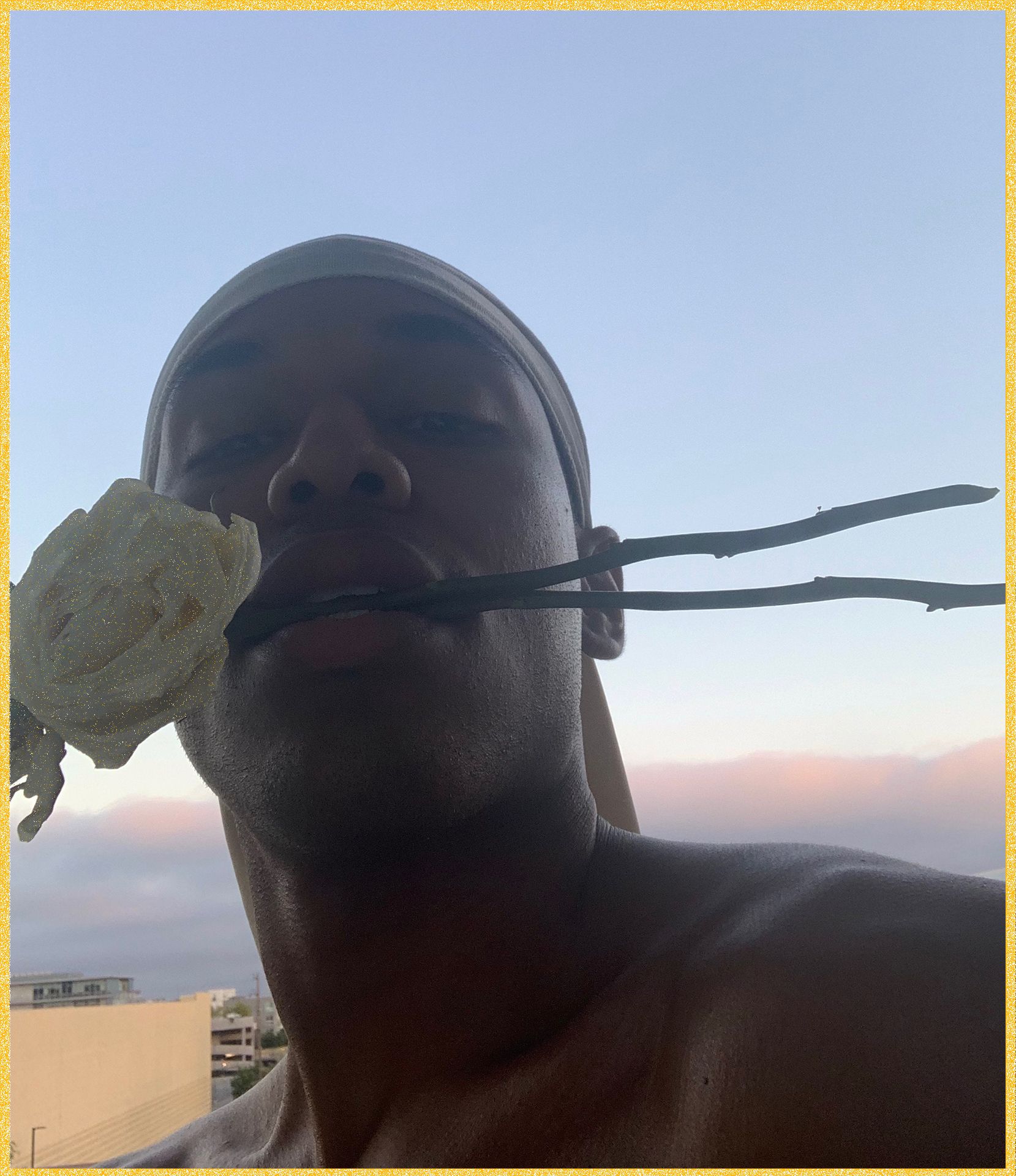 Kelvin Harrison Jr. cover self-portrait posing with yellow flowers in mouth