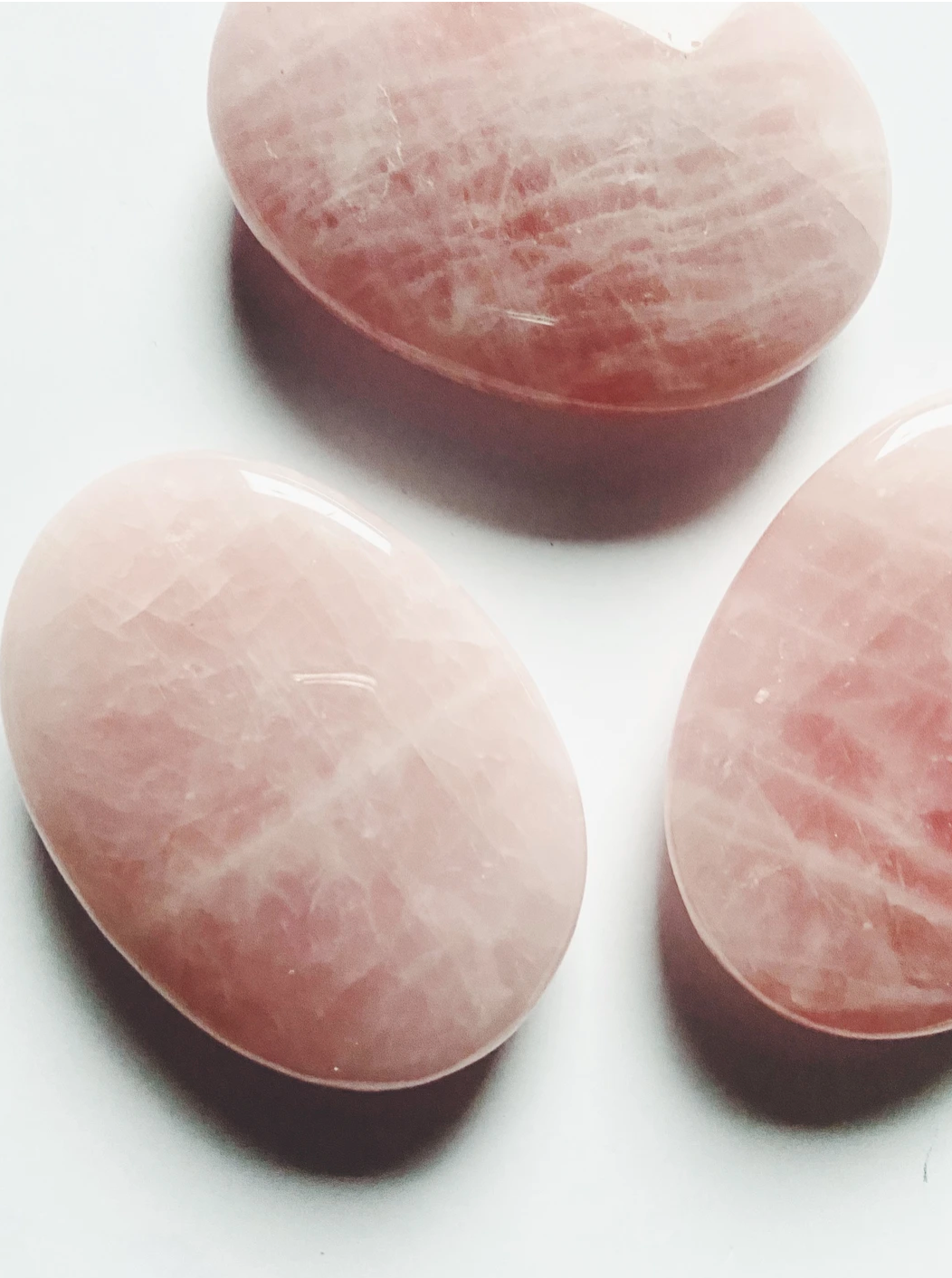 three rose quartz flat stones